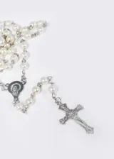 Cadena tipo rosario con cuentas redondas color blanco perla y crucifijo plateado.