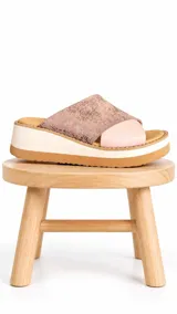 Sandalia de plataforma con capellada de cuero en tonos rosa y rosado metalizado con textura. Cuenta con suela corrida de estilo deportivo en color blanco y base marrón.