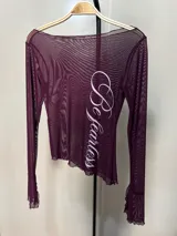 Blusa de mesh negra con transparencias, manga larga y estampa frontal en tipografía vintage color blanco.