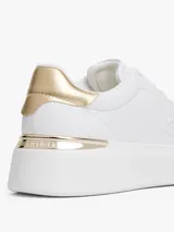 Zapatillas de plataforma Tommy Hilfiger, color blanco, con detalles metálicos dorados en el talón y monograma TH grabado en el lateral. Diseño de corte bajo con cierre de cordones.