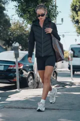 Cazadora de mujer con diseño híbrido, presenta un panel frontal acolchado con costuras en chevron y mangas y laterales en tejido liso. Cuenta con cuello alto, capucha ajustable con cordones elásticos y cierre frontal mediante cremallera.