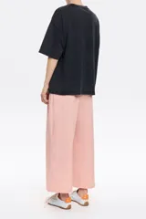 Pantalón tobillero de algodón color beige, de corte recto con cierre frontal de corchete oculto y cremallera, pinzas en la parte delantera y presillas de tela. Presenta bolsillos diagonales delanteros y bolsillos traseros con vivo.