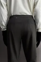 Pantalón de jogging negro confeccionado en tejido técnico ligero y elástico, corte slim fit, con cintura elástica ajustable con cordón, bolsillos laterales y trasero con cierre de cremallera, bandas reflectantes en las piernas y bajos ajustables con cremallera.