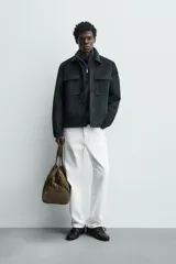 Sobrecamisa regular fit color verde oscuro, confeccionada en tejido efecto ante. Cuenta con cuello solapa, manga larga con puño abotonado, bolsillos de plastrón con solapa en el pecho y bolsillos de vivo en la cadera. El cierre es frontal con botonadura.