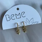 Aros colgantes dorados con forma de hojas y pequeños brillantes incrustados.