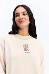 Buzo de algodón con efecto acid wash y diseño vintage. Presenta cuello redondo, mangas largas con puños acanalados, bolsillo frontal tipo canguro y estampa gráfica pequeña en el pecho.