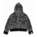 Buzo con cierre frontal completo, confeccionado en tejido de punto grueso de algodón. Presenta un diseño estampado integral con motivos gráficos y tipografía estilo gótico en tonos gris y negro, capucha integrada, puños y ruedo acanalados en color negro sólido.