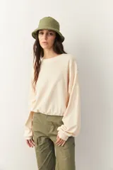 Buzo celeste cropped de manga larga con puños y cordones ajustables en la cintura.