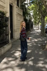 Sweater de tejido bremer con diseño a rayas horizontales en tonos bordó, azul marino y blanco. Presenta cuello polo en color crema y mangas largas con puños ajustados.