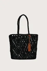 Bolsa tipo tote tejida en crochet con diseño de diamantes en color negro. Cuenta con doble asa superior trenzada y un detalle de etiqueta de cuero sintético color suela colgando de una de las asas.