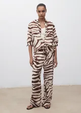 Pantalón fluido de tiro medio con estampado de cebra, diseño recto y largo, cintura elástica con cordón de ajuste y forro interior de algodón.