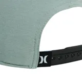 Gorra tipo snapback de color gris oscuro, con visera plana y logo Hurley bordado en negro en el panel frontal. Presenta paneles laterales y traseros con perforaciones para ventilación.