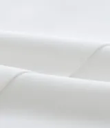 Bermuda de tiro alto confeccionada en crepé color blanco, con cierre frontal, bolsillos laterales y detalle de botones decorativos.
