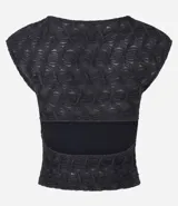Blusa sin mangas de color negro, confeccionada en tejido texturizado con cuello redondo y abertura en la espalda.