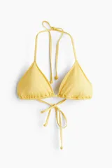 Top de bikini forrado de color amarillo, con copas triangulares y relleno extraíble, tiras ajustables para atar en el cuello y la espalda.