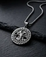 Collar de acero inoxidable con cadena de eslabones tipo caja y dije circular con diseño grabado del árbol de la vida rodeado de runas.