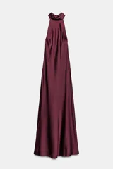 Vestido largo de satén en color bordó, con cuello halter y detalle de lazada en el cuello. Presenta un diseño fluido con espalda descubierta.