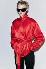 Cazadora corta de Zara color rojo, con cuello smoking, manga larga y cinturón ajustable del mismo tejido.