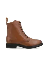 Borcego acordonado de cuero vacuno color suela, con suela de goma negra y cierre lateral. Presenta logo de la marca grabado en el lateral y cordones al tono.