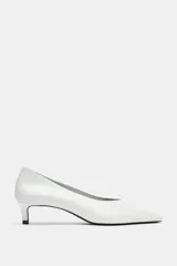 Zapato de tacón tipo kitten, confeccionado en piel soft color blanco, con diseño de escote en pico, acabado en punta y tacón fino.