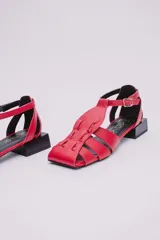 Sandalias de cuero estilo jaula en color rojo, con punta cuadrada, taco cuadrado bajo en color negro y cierre con hebilla ajustable en el tobillo.