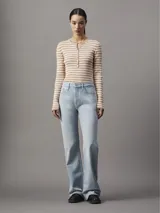 Campera puffer corta color blanco, confeccionada en nailon reciclado con acabado brillante. Tiene cuello alto, cierre frontal con cremallera, bolsillos laterales con cremallera y logo de Calvin Klein en el pecho.