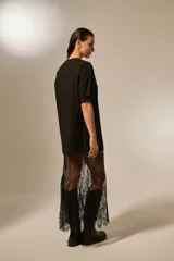 Vestido largo negro de algodón, corte holgado, con cuello redondo y sobrefalda de encaje negro transparente.