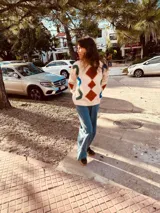 Sweater color crema con bordados geométricos en azul, verde, rojo y marrón. Tiene cuello redondo y mangas largas. Corte holgado.