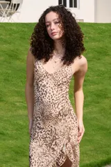 Vestido midi de poliéster con estampado animal print de leopardo, escote en V y diseño asimétrico con tajo en la pierna.