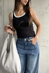 Musculosa de algodón color negro con ribetes blancos en el cuello y las sisas, de corte al cuerpo.