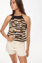 Top tejido a mano con diseño artesanal y patrón geométrico abstracto en tonos negro, tostado y crudo, con escote halter.