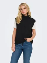 Chaleco tejido de punto con diseño de trenzas, cuello alto tipo polera y terminaciones acanaladas en el ruedo y sisas.