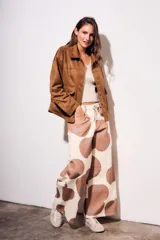 Sobrecamisa marrón de gamuza sintética, con cuello camisero, cierre frontal con botones, mangas largas con puños abotonados y bolsillos de parche en el pecho.