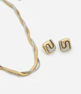 Conjunto de bijouterie compuesto por un collar de cadena tipo rabo de rata entrelazada en tonos dorado y plateado, y un par de aros tipo botón con diseño cuadrado bicolor.