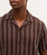 Camisa de manga corta para hombre, confeccionada en tejido jacquard marrón con rayas y textura. Presenta cuello solapa y cierre frontal de botones.
