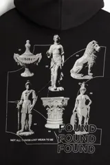 Canguro negro de mezcla de algodón de peso medio con interior cepillado suave. Cuenta con capucha de doble capa con cordón ajustable, hombros caídos, bolsillo canguro y puños y bajo acanalados. Presenta un estampado frontal de un león sentado con texto en blanco.