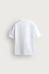 Remera de corte relaxed fit confeccionada en tejido de algodón con textura irregular, cuello redondo y manga corta.