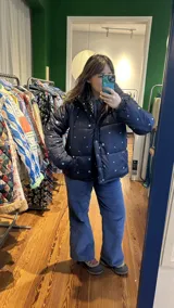 Pantalón de jean azul con bolsillos frontales y traseros. Presenta bordados de flores en los bolsillos traseros.