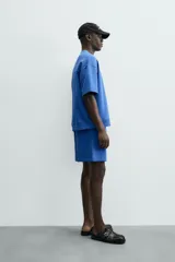 Sudadera de manga corta color marrón oscuro, con cuello redondo y bajo acabado en rib. Presenta un corte relajado y holgado (boxy fit).