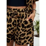 Conjunto de dos piezas compuesto por una camisa de manga corta con cuello italiano y cierre frontal de botones, y un short con cintura elástica y bolsillos laterales. Ambas prendas presentan un diseño estampado de animal print.