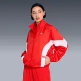 Campera Puma modelo Wardrobe Essentials, color rojo con bandas blancas en las mangas y el torso, cuello semi-alto y cierre frontal. Incorpora tecnología windCELL para protección contra el viento y cuenta con el logo de la marca bordado en el pecho.
