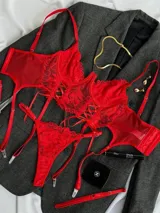 Conjunto de lencería rojo de encaje floral, compuesto por un corpiño tipo corset con aro y tirantes finos, una bombacha colaless regulable y ligas con cintas ajustables.