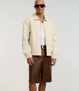 Bermuda baggy de poliuretano color marrón, con diseño amplio y efecto gastado, cintura con trabillas, bolsillos delanteros y traseros.