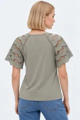 Remera color verde militar con cuello en V y mangas cortas confeccionadas en tejido broderie con detalles calados.