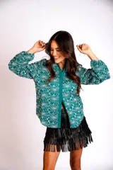 Camisa color crema con bordado de flores blancas, de manga larga abullonada y cuello clásico.