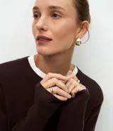 Cardigan de punto color marrón chocolate, con cuello redondo, cierre frontal con botones y mangas largas. Presenta un diseño clásico con acabado canelado en el escote y los puños.