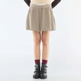 Falda corta estilo globo con estampado de cuadros pequeños en tonos beige y marrón. Presenta una cintura elástica cómoda y un corte voluminoso característico del diseño tipo globo.