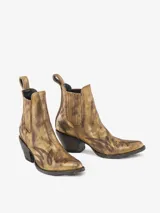 Bota corta estilo texana/cowboy de cuero con acabado metálico dorado envejecido y detalles de grabado en la puntera y el lateral. Posee elásticos laterales y un tacón ancho y bajo.