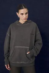 Buzo hoodie de corte oversize en color gris con efecto desgastado, cuenta con capucha, bolsillo frontal tipo canguro y logo bordado en el pecho.