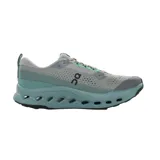 Championes de running On Running modelo Cloudsurfer Trail 2 M, color gris con detalles en verde y suela turquesa con perforaciones y diseño ondulado.